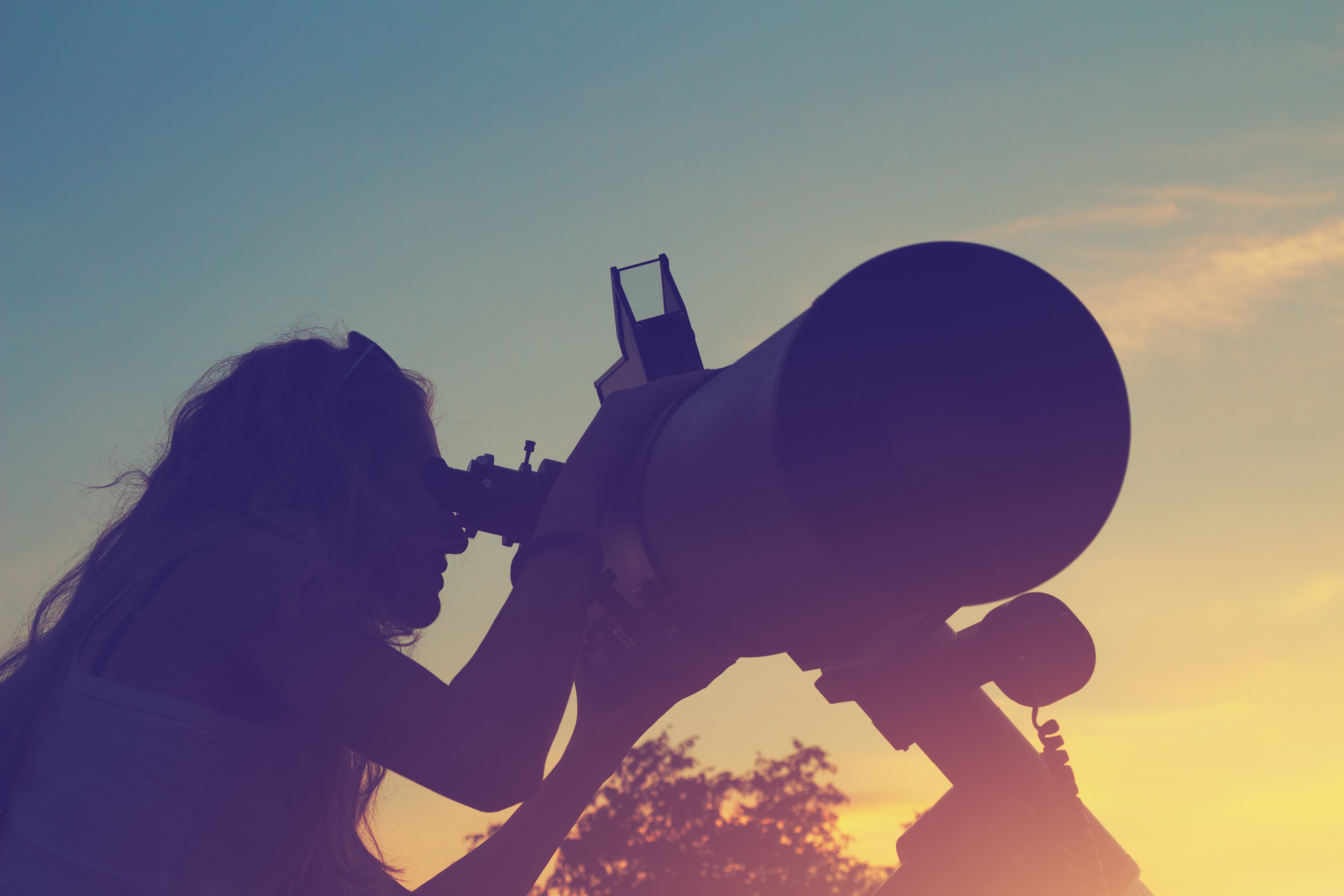 Girl looking through a telescope 